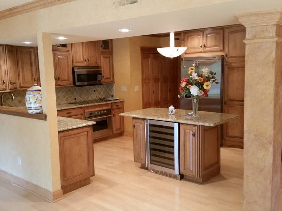 Custom kitchen with granite island, wine fridge, and cabinetry