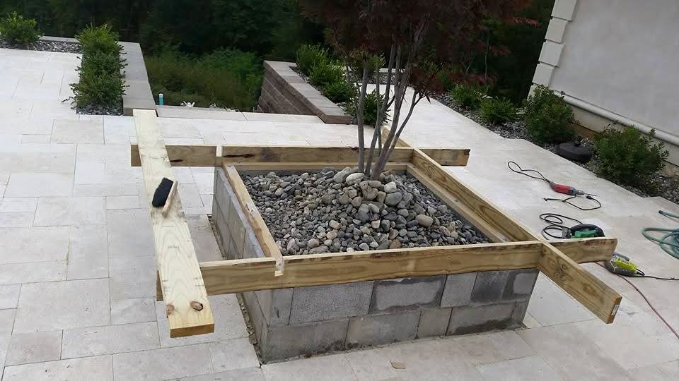 Custom planter box framing under construction on stone patio